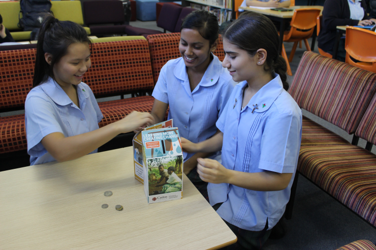Students from Delany College, Granville have been generously donating to Project Compassion, raising over $2000. From left to right:  Year 11 students Hilary Lim, Divashna Kumar and Elisar Salameh busy counting the coins.