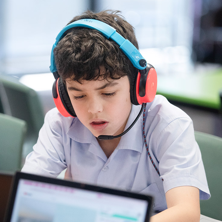 St Bernadette's Catholic Primary School Lalor Park boy learning on laptop with headphones